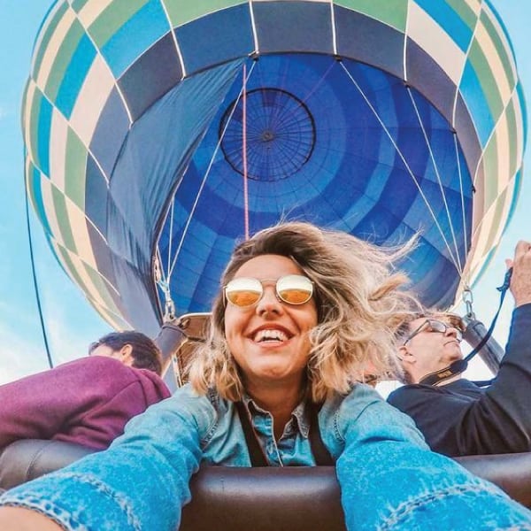 A passenger in a hot-air balloon takes a mid-flight selfie