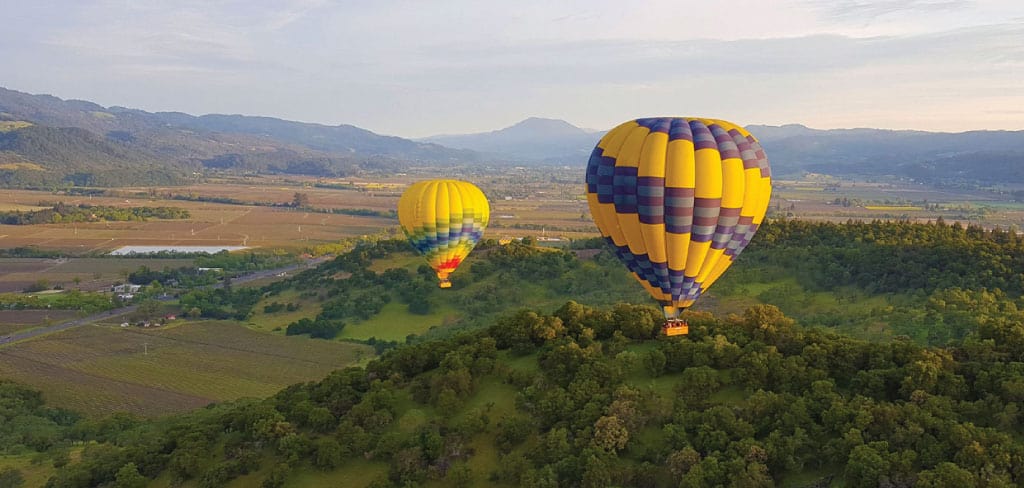 Two hot-air ballons float over the vineyards in Napa Valley