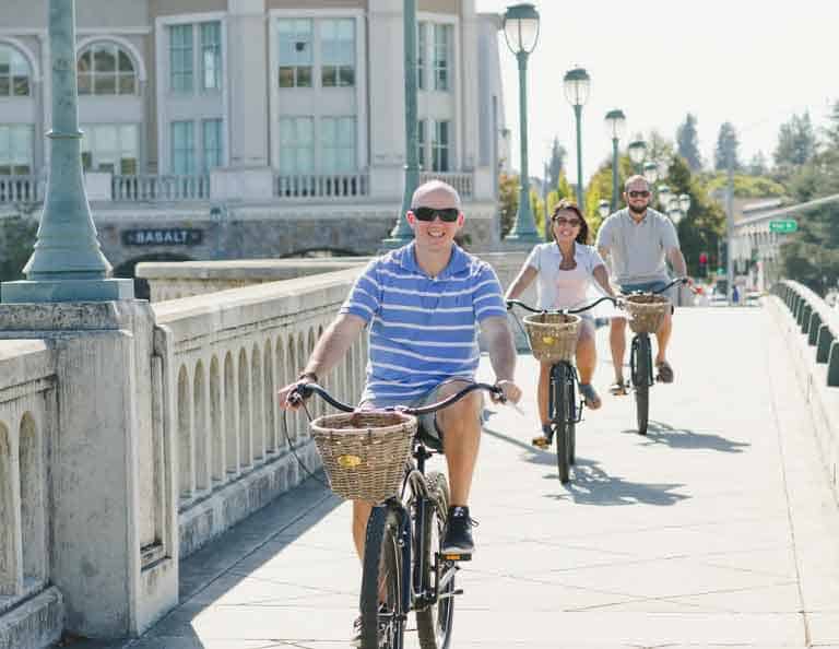 Three people riding bikes in Downtown Napa